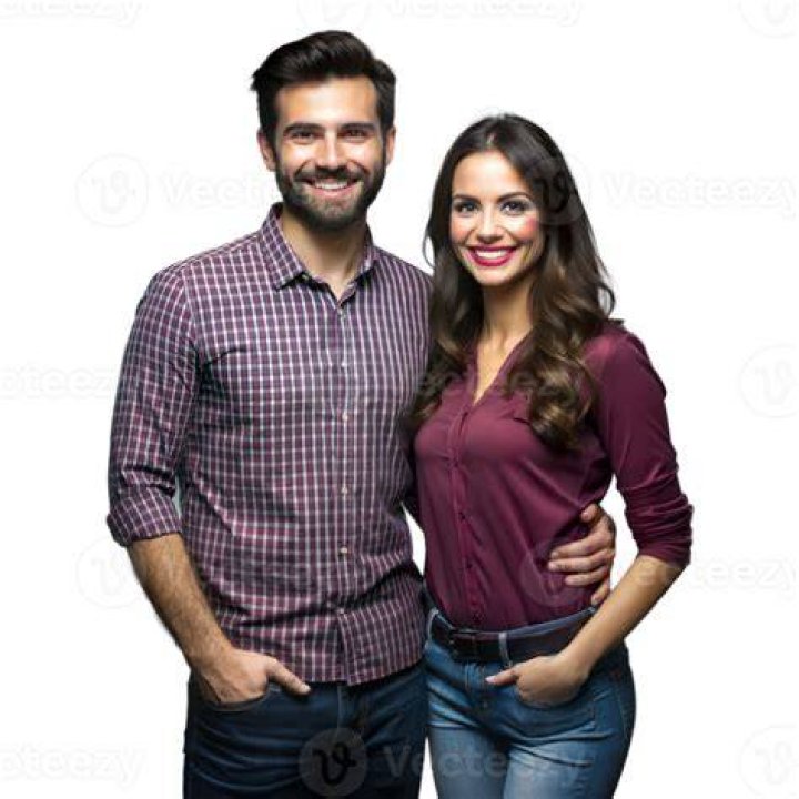 a man and woman standing next to each other in front of a window